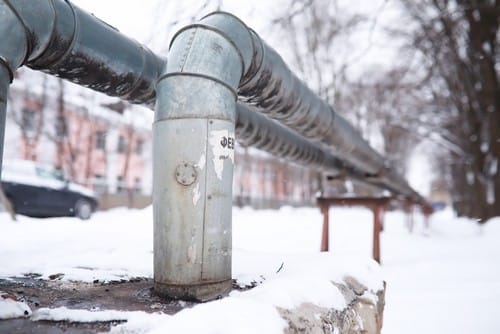 Winter landscape with the snow-covered gas pipeline
